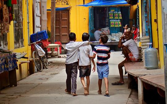 Children walking in the streets of India hugging each other